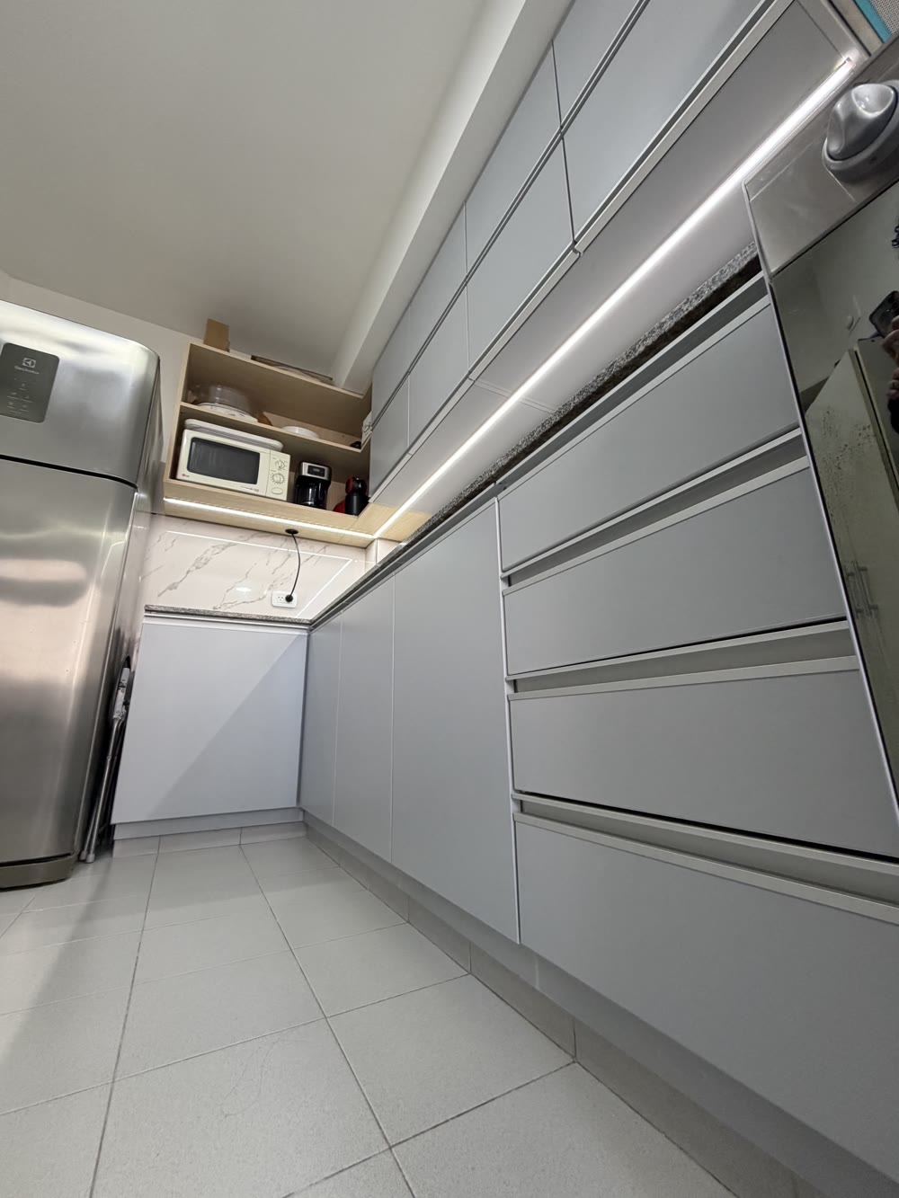 Cocina gris de MARQ con heladera y alacenas