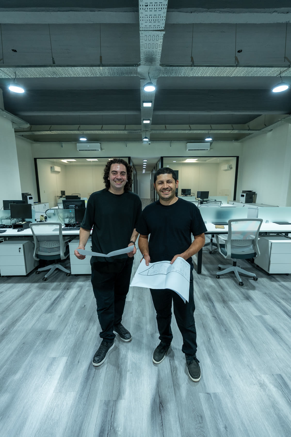 Mariano y Maximiliano, el equipo de MARQ, en la oficina con un plano